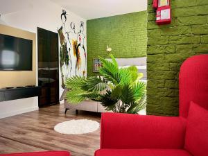 a living room with a red couch and a green wall at Macedonia Square Suite 22 - Pedestrian Street in Skopje
