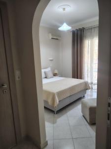 a bedroom with a bed and an arched doorway at Vicky's Guesthouse in Kavos