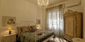 a bedroom with a bed and a chandelier at Giardino D'amore By Belcanto Villas in Piano di Mommio