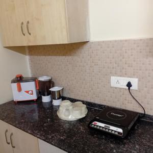 eine Küchentheke mit Tassen und Geräten darauf in der Unterkunft Organic Stay in Greater Noida + 30 Fotos