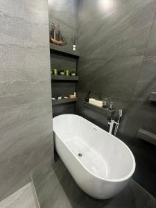 a white bath tub in a bathroom with gray walls at Luxury Residence in Mirabad Avenue in Toshkent-Passajir Bekati +25 photos