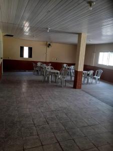 a room with tables and chairs in a building at CHÁCARA PARA ROMEIROS- próximo ao santuário de nossa senhora in Roseira