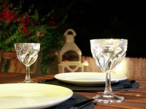 twee lege wijnglazen zittend op een houten tafel bij Pretty Holiday Home in Grays in Loutra