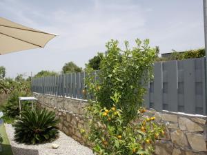 an orange tree next to a stone wall at Pretty Holiday Home in Grays in Loutra