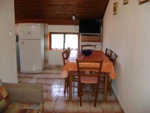 a kitchen with a table with chairs and a refrigerator at Apartments Radulović in Biograd na Moru