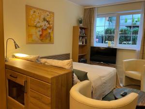 a bedroom with a bed and a desk with a chair at Lovely Souterrain Apartment in Solingen