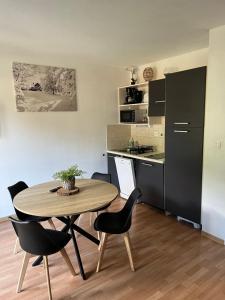 - une cuisine et une table avec des chaises dans la chambre dans l'établissement Studio vue piste + parking souterrain privatif inclus, aux Orres
