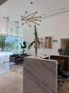 Una sala de estar con una mesa con una planta en maceta. en New luxury apartment, en Mérida 42 fotos más