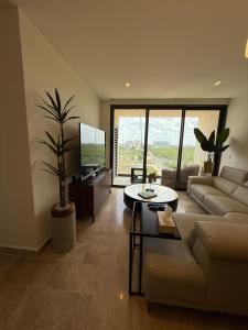 una sala de estar con un sofá y una mesa en New luxury apartment, en Mérida