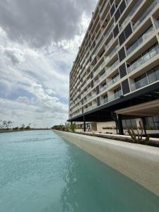 un gran edificio junto a una masa de agua en New luxury apartment, en Mérida