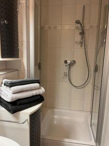 a bathroom with a shower and a bath tub with towels at Lovely Souterrain Apartment in Solingen
