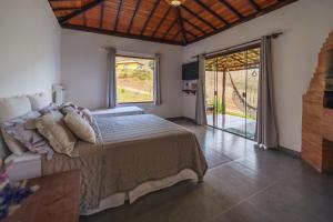 a bedroom with a bed and a large window at Casa Cambuí Hospedagem Rural in Rio Prêto