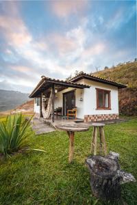 a small white house with a table in front of it at Casa Cambuí Hospedagem Rural in São José do Rio Preto