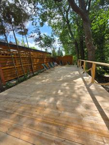 a wooden walkway with chairs on it in a park at Nowy domek drewniany Tu Mi Dobrze w Lubkowie z plażą in Lubkowo +11 photos