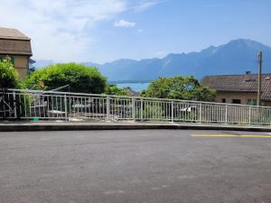 VeytauxStudio with a view of Lake Geneva的湖边街道旁的白色栅栏