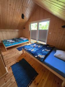an attic room with two beds and a window at Nowy domek drewniany Tu Mi Dobrze w Lubkowie z plażą in Lubkowo