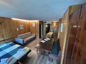 a room with a bed and a couch and a table at Rododendro Ski-in Ski-out CIR 0491 in Breuil-Cervinia