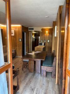 a kitchen with a table and a bench in a room at Rododendro Ski-in Ski-out CIR 0491 in Breuil-Cervinia