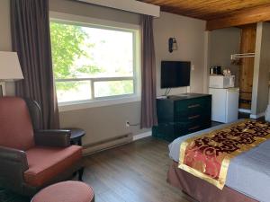 a hotel room with a bed and a chair and a window at Rondo Motel in Golden