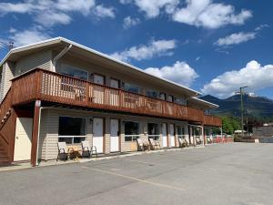 a building with a balcony with chairs in a parking lot at Rondo Motel in Golden
