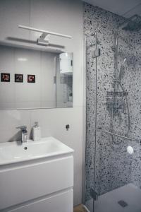 a bathroom with a sink and a glass shower at Słoneczna Bryza - domek, pokoje i apartamenty in Gąski