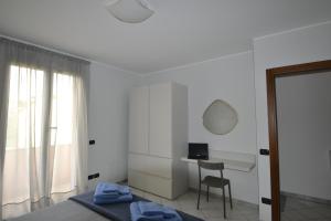 a bedroom with a bed and a desk and a mirror at Appartamento Camineve 2 in Loano
