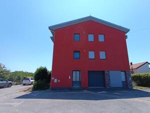 a red building with a blue door in a parking lot at Rijeka - Charming apartment with Sea View and Private Parking in Rijeka