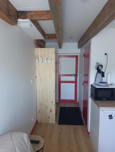 a small room with a red door and a kitchen at Logements Clos saint Genest 1appartement et 3 studios in Manzat +26 photos