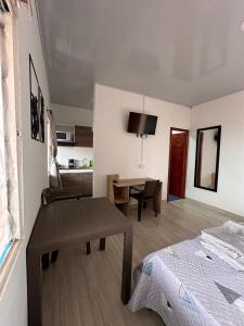 a room with a bed and a table and a kitchen at Apartaestudios Santa Ana in Ruiosucio