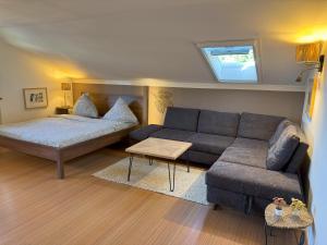 a living room with a couch and a bed at Ferienwohnung WaldGlück mit Pool & Sauna in Hauzenberg