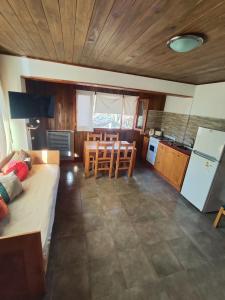 a living room with a couch and a table and a kitchen at Departamento Campanita in San Martín de los Andes +5 photos