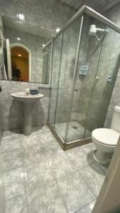 a bathroom with a shower and a toilet and a sink at Casa Maré in Búzios