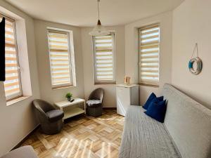 a living room with a couch and chairs and windows at Róża Wiatrów in Sztutowo