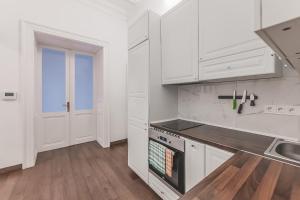 a white kitchen with white cabinets and a stove at Heart of Prague Lodgings 4 in Prague