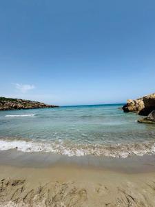 una spiaggia con l'oceano e rocce sullo sfondo di oasis home a Reitani
