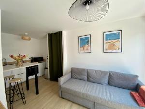 a living room with a couch and a kitchen at Le Colinou Chambretaud - 5min du PUYDUFOU in Chambretaud