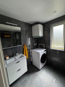 a bathroom with a sink and a washing machine at Villa Söderläget in Laholm +18 photos