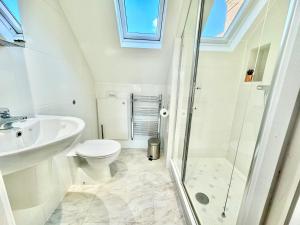 a bathroom with a toilet and a sink and a shower at Stunning 2 bed, 2 bath Summertown Oxford in Oxford +5 photos