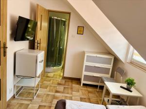 a living room with a staircase with a refrigerator and a table at Róża Wiatrów in Sztutowo
