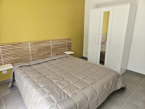 Un dormitorio con una cama grande y una pared amarilla. en Appartement 2 chambres avec jardin Gap Charance Hautes-Alpes, en Gap