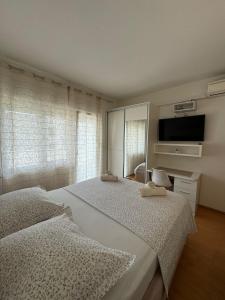 een slaapkamer met 2 aparte bedden en een televisie bij Apartments Mimi Omis in Omiš