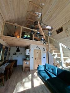 a living room with a blue couch and a wooden ceiling at Woodland House 2 in Berezka