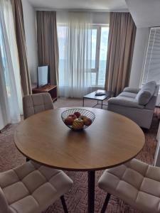 a living room with a bowl of fruit on a table at Elite Family Hotel in Kiten