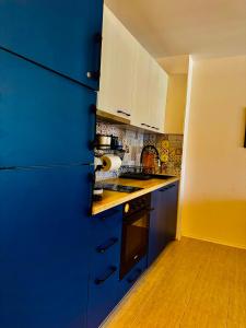 a kitchen with blue cabinets and a blue refrigerator at Apartment Beach Kavatsi in Sozopol