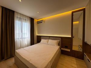 a bedroom with a large bed and a window at Odi Apartments in Durrës