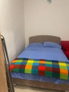 a bed with a colorful blanket on top of it at Apartmani Marina Sutomore in Sutomore