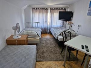 mały pokój z 2 łóżkami i telewizorem w obiekcie Apartament Cichy i Wygodny w mieście Stalowa Wola +30 zdjęć