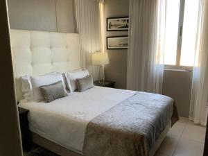 a bedroom with a large white bed with pillows at Infinity Beach view in Cape Town