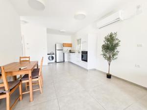 a kitchen and dining room with a table and a plant at המקום של אסי - Assi's place in Oshrat