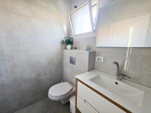 a bathroom with a toilet and a sink at המקום של אסי - Assi's place in Oshrat +28 photos